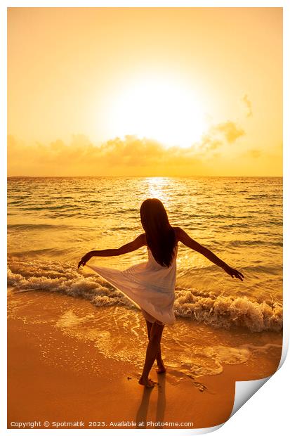 Asian girl standing in ocean waves at sunrise Print by Spotmatik 