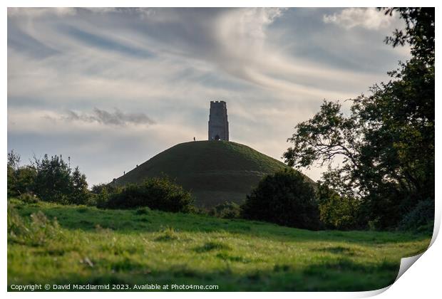 A large green field with trees in the background with Glastonbury Tor in the background Print by David Macdiarmid