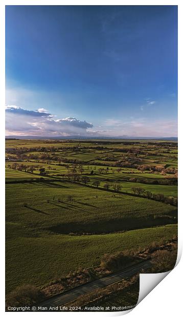 Scenic aerial view of lush green fields under a dramatic sky at dusk, showcasing the beauty of rural landscapes in North Yorkshire. Print by Man And Life