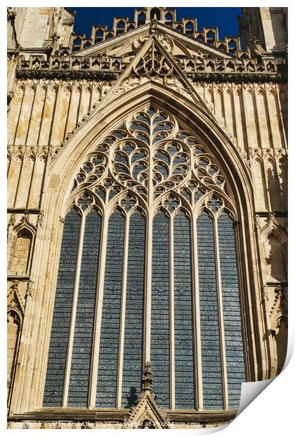 Gothic architecture detail of a cathedral window with intricate tracery and stained glass, set against a clear blue sky in York, North Yorkshire, England. Print by Man And Life